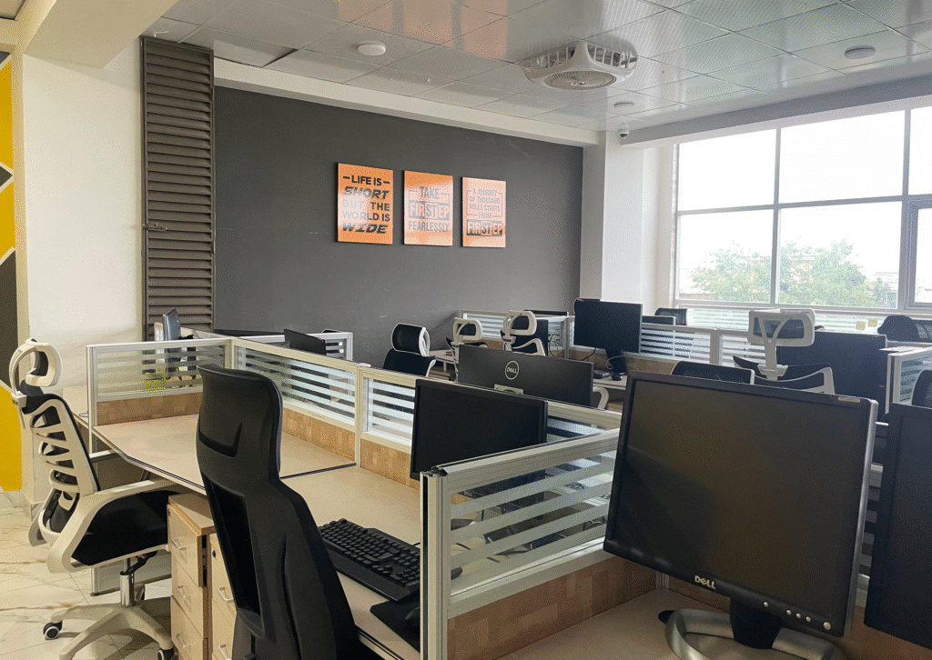 A desk with 4 persons sitting capacity equipped with 4 personal computers.